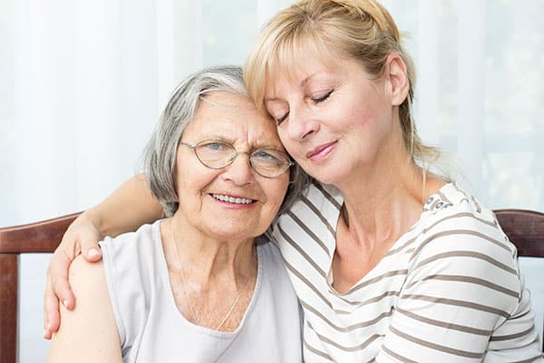 caregiver comforting elderly woman
