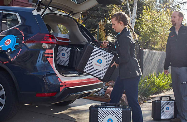 young female professional loading up her car with boxes