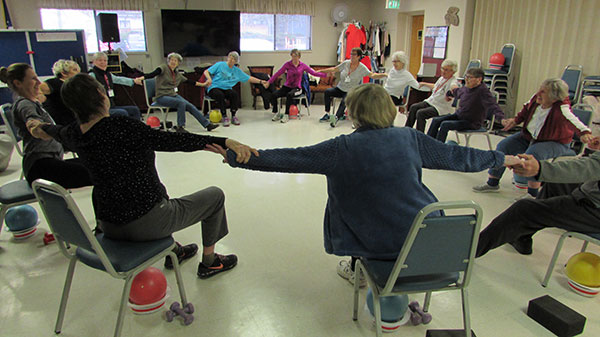 seniors sitting in a circle while holding hands