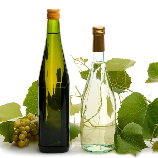 grape vines and bottles of wine on a table