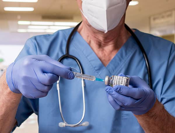 nurse holding syringe and vaccine