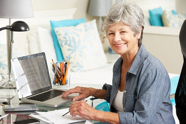 senior woman sitting in front of her computer