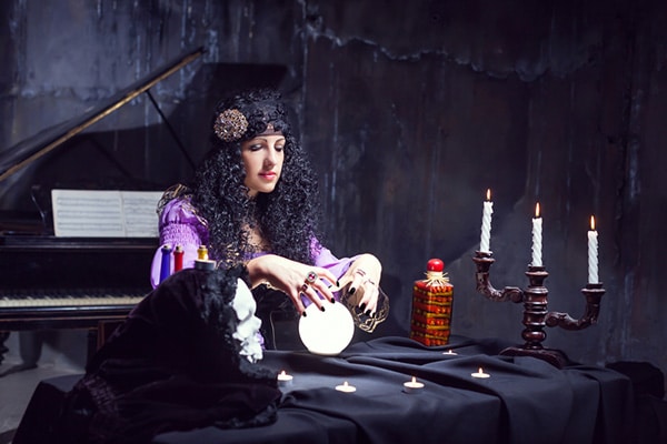 woman dressed like witch gazing into her crystal ball