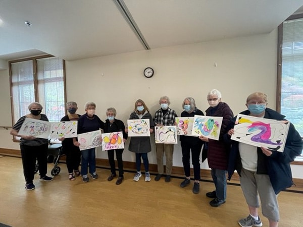 group of residents holding up their handmade art