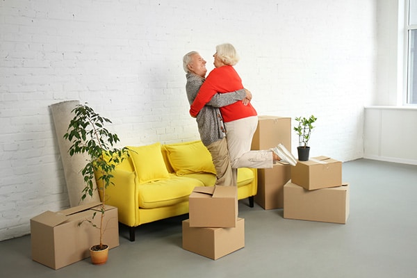 senior coupple hugging while packing boxes