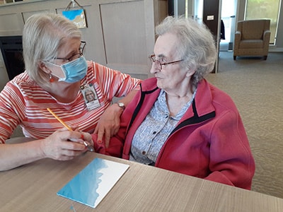 caregiver helping senior woman create a shopping list