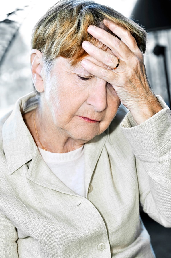 senior woman resting her head against her hand