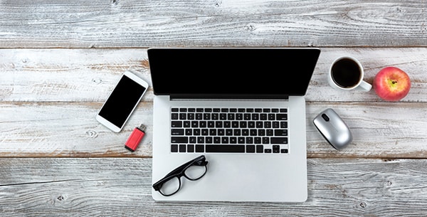 laptop and other things resting on a rustic table