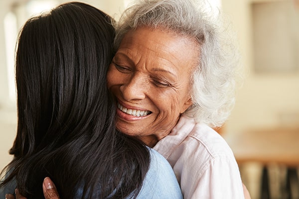 two senior woman embracing each other