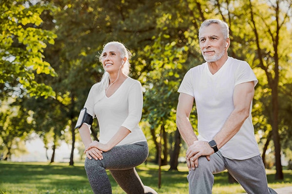 a senior couple doing yoga in a park