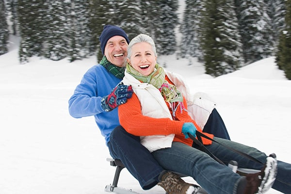 senior couple sledding