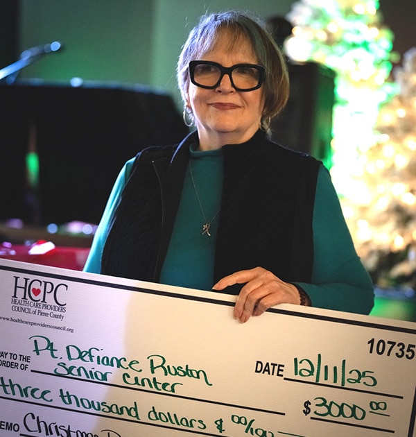 senior woman holding large check