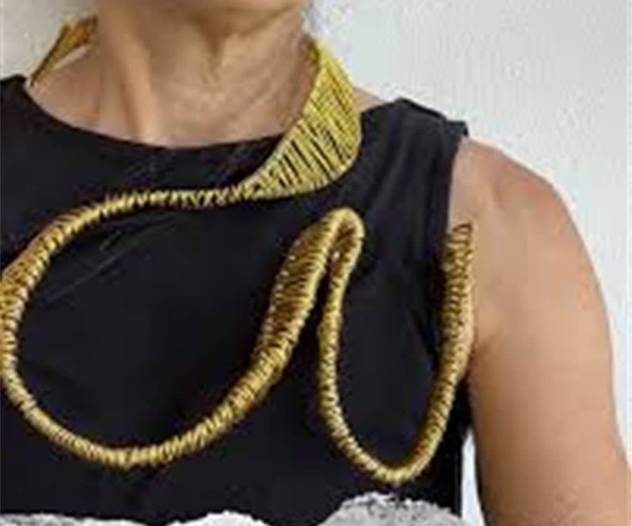 close up of a woman wearing a decorative art piece around her neck