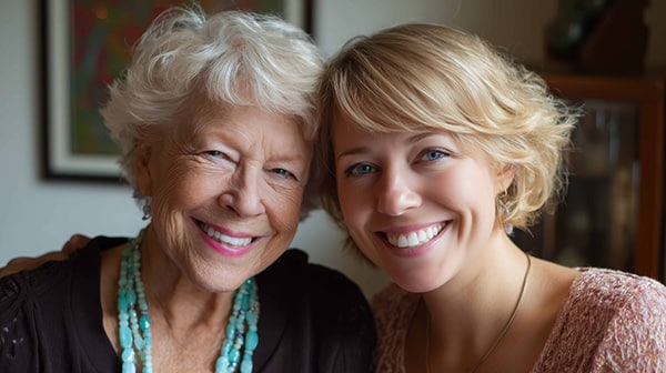 Adult daughter and senior mother smiling for the camera